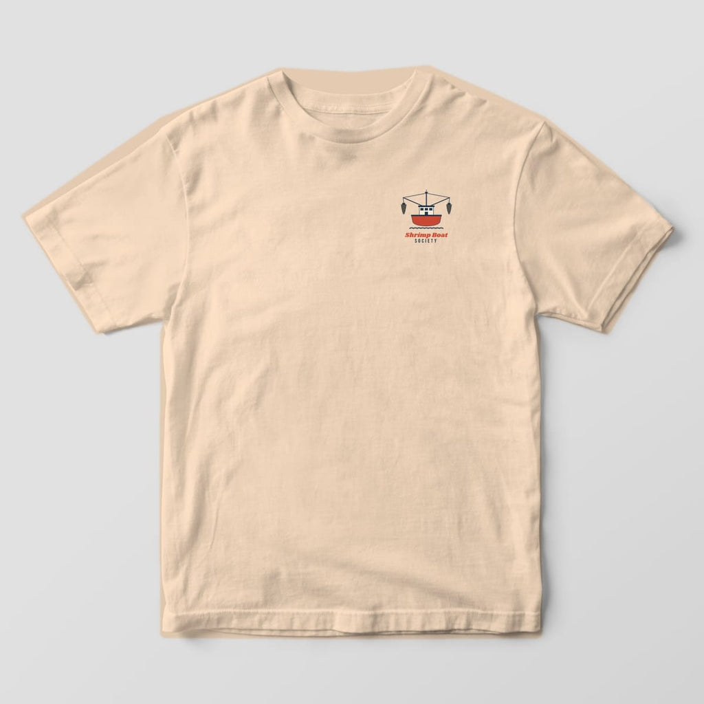 Front of an Ivory Comfort Colors 1717 tee with a small trawler icon and Shrimp Boat Society lettering on the left chest.