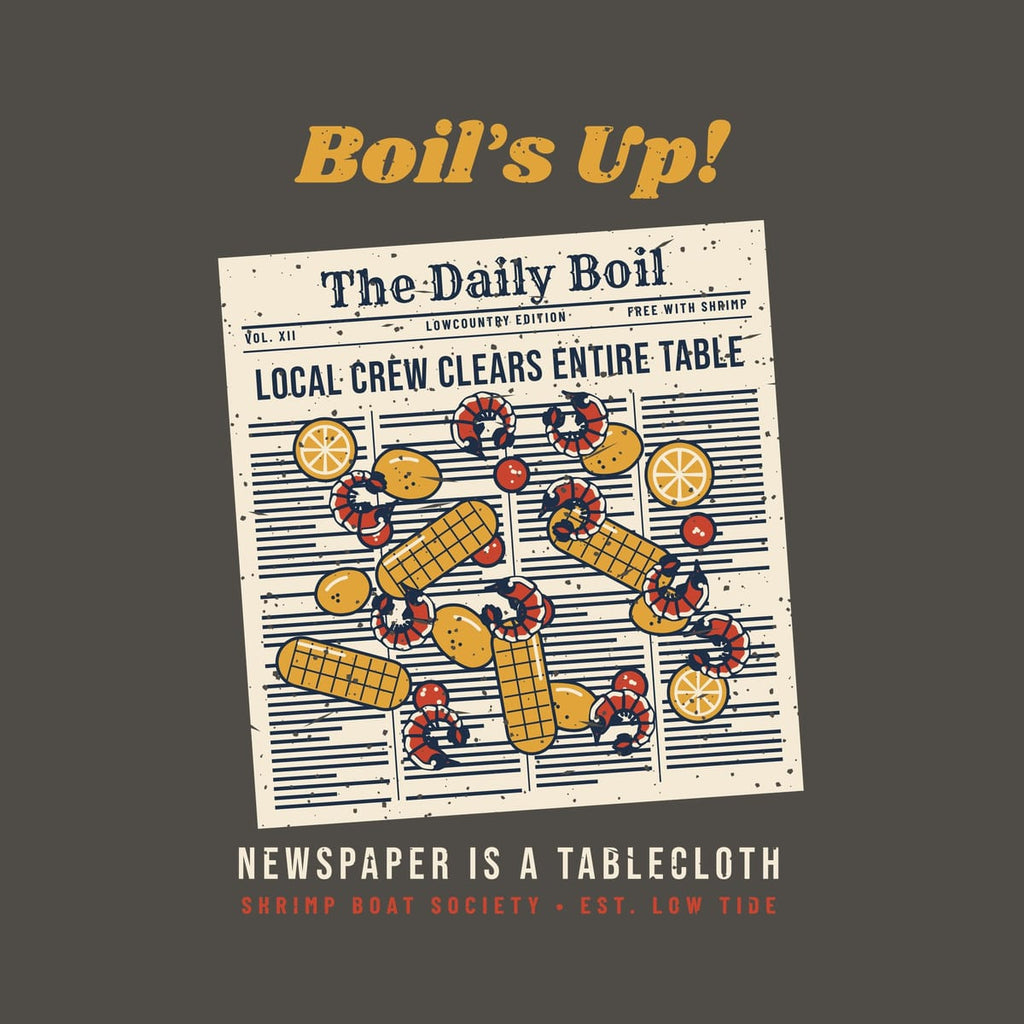 Close-up of the boil spread print: curled shrimp, corn cobs, lemon halves and sausage coins over newspaper columns and a Daily Boil masthead.
