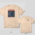 Ivory Comfort Colors tee shown back and front: a navy seafood-shack menu board on the back and a small life ring monogram on the left chest.