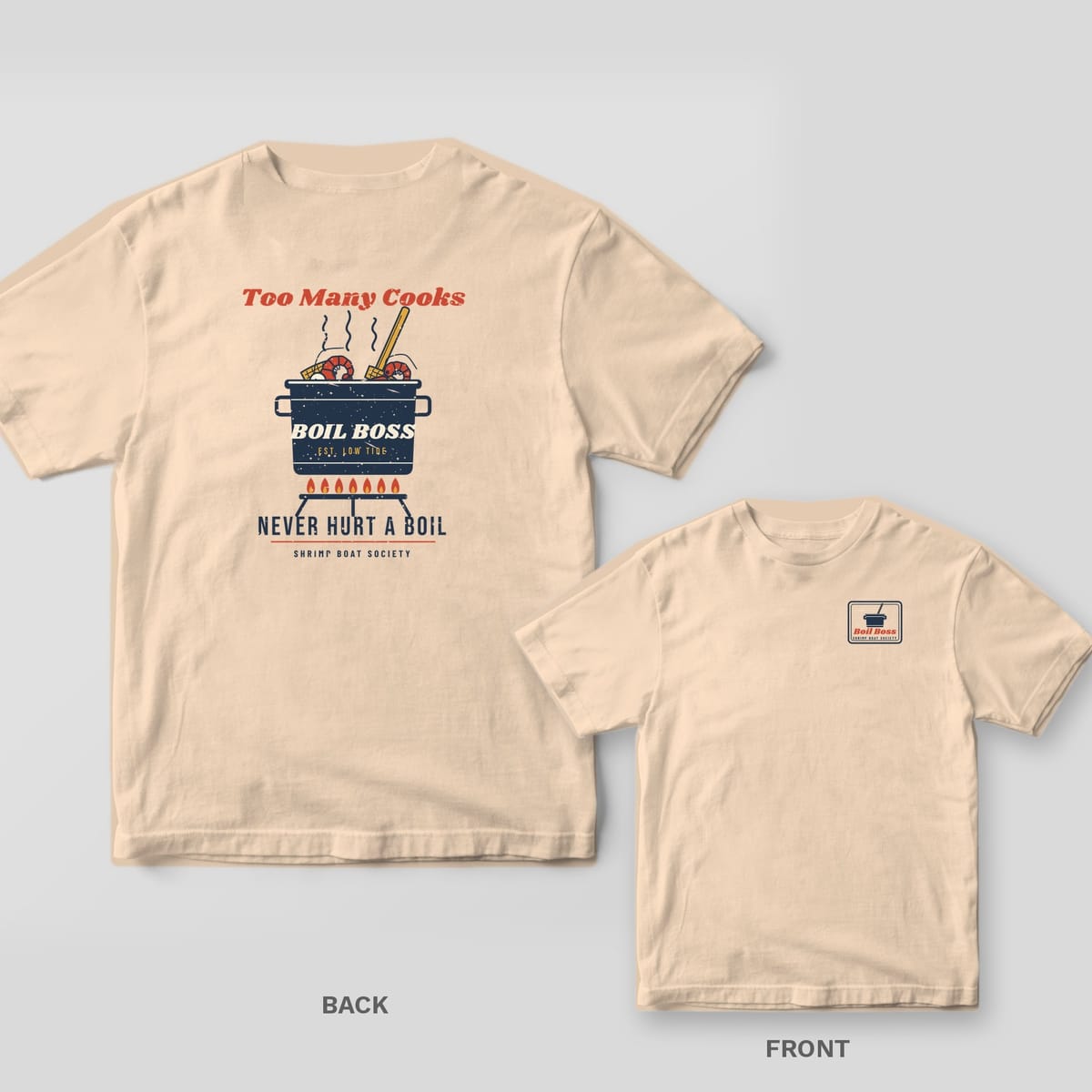 Ivory Comfort Colors tee back with a boil pot full of shrimp and corn and Too Many Cooks Never Hurt a Boil text, with the Boil Boss pocket stamp inset