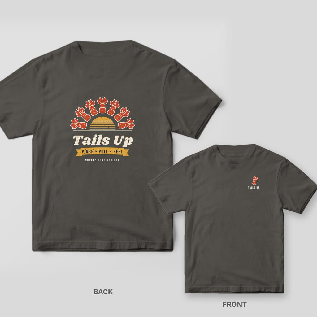 Pepper Comfort Colors tee back with a sunburst of shrimp tails over a gold sun and Tails Up lettering, with the small tail chest print inset