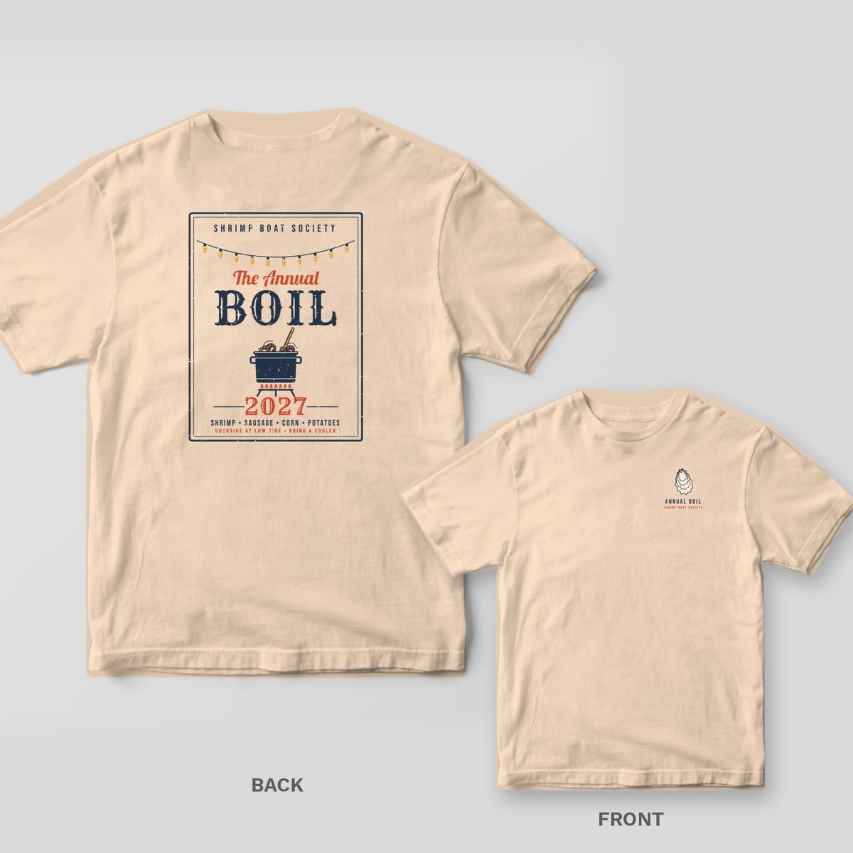 Ivory Comfort Colors tee back with a framed Annual Boil event poster showing string lights, a boil pot and the year 2027, with the oyster chest print inset