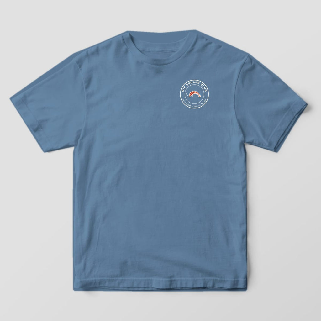 Front of a blue jean Comfort Colors 1717 tee with a small round HIP ESCAPE CLUB shrimp badge on the left chest.
