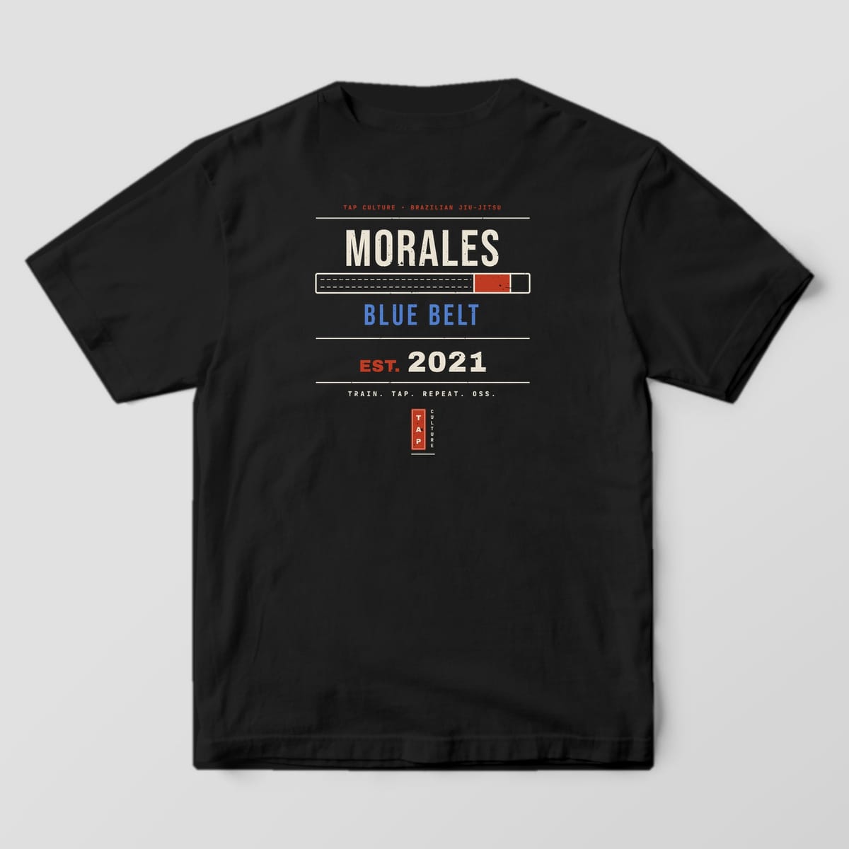 Back of a black Comfort Colors 1717 tee with a personalized name, belt bar, rank and start year in cream, blue and red.