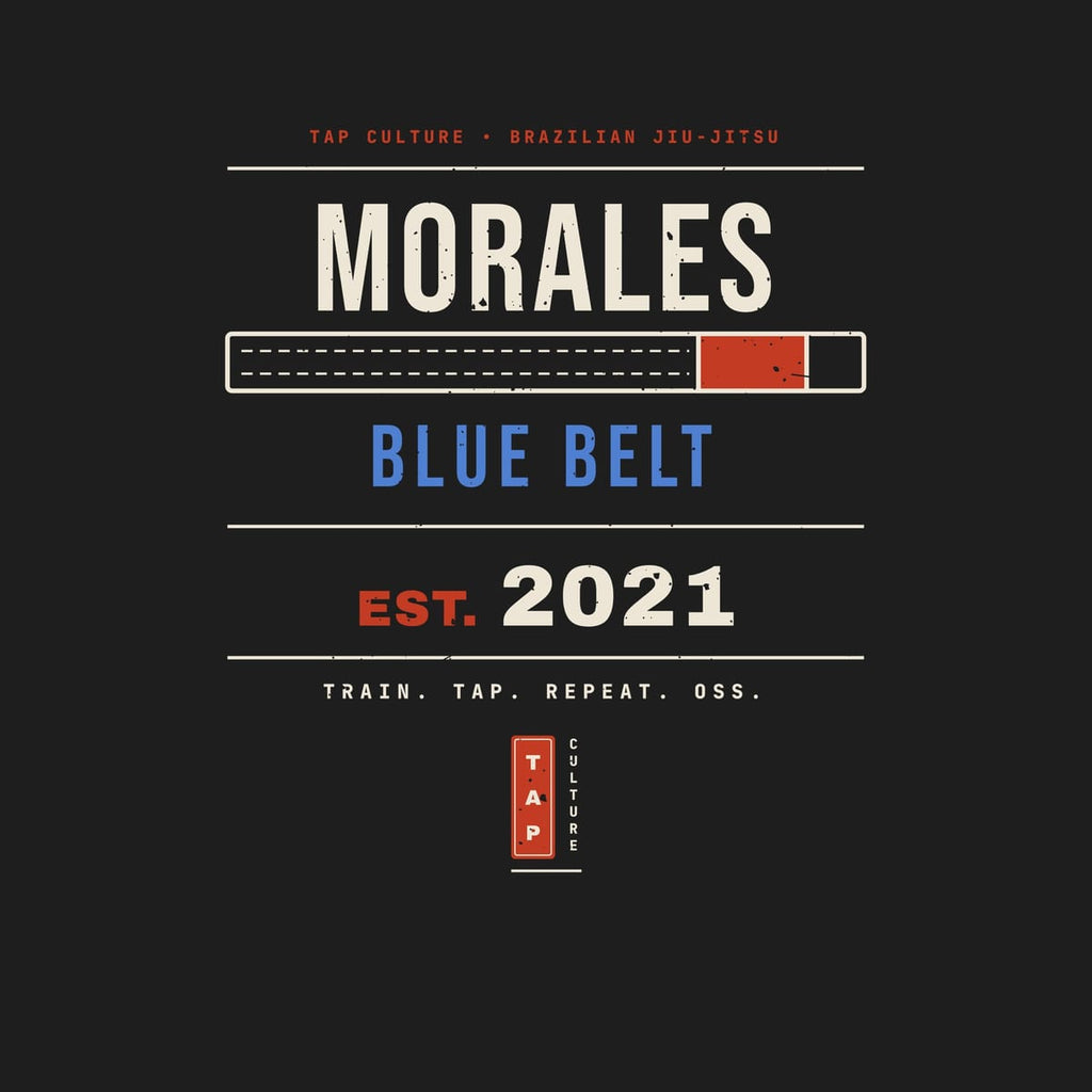 Close-up of the personalized back print showing the name lettering, belt bar, rank, EST. year and red TAP seal.
