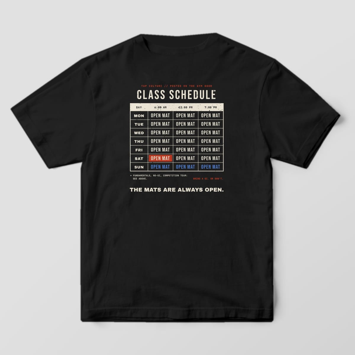 Back of a black Comfort Colors 1717 tee with a cream schedule grid, every day and time reading OPEN MAT.