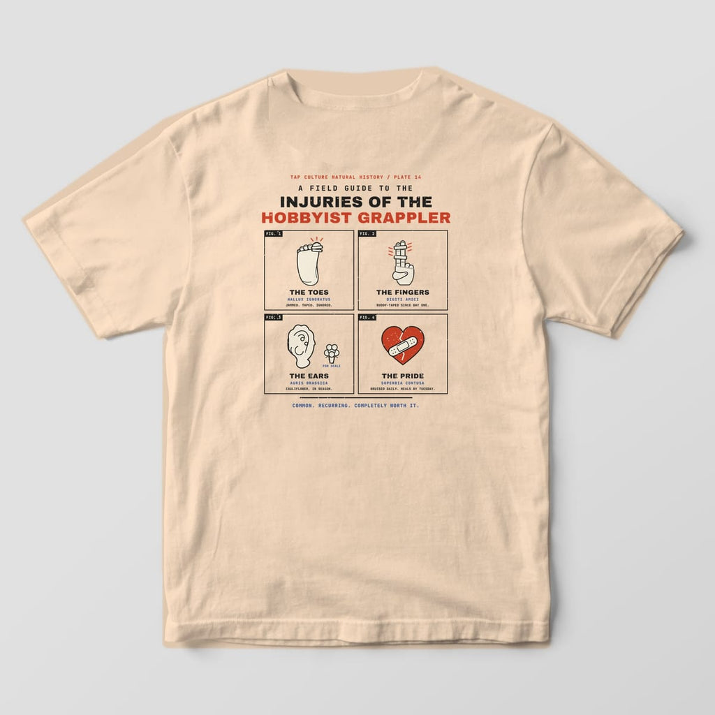 Back of an ivory Comfort Colors 1717 tee with four framed drawings: a taped toe, taped fingers, a cauliflower ear and a bandaged heart.