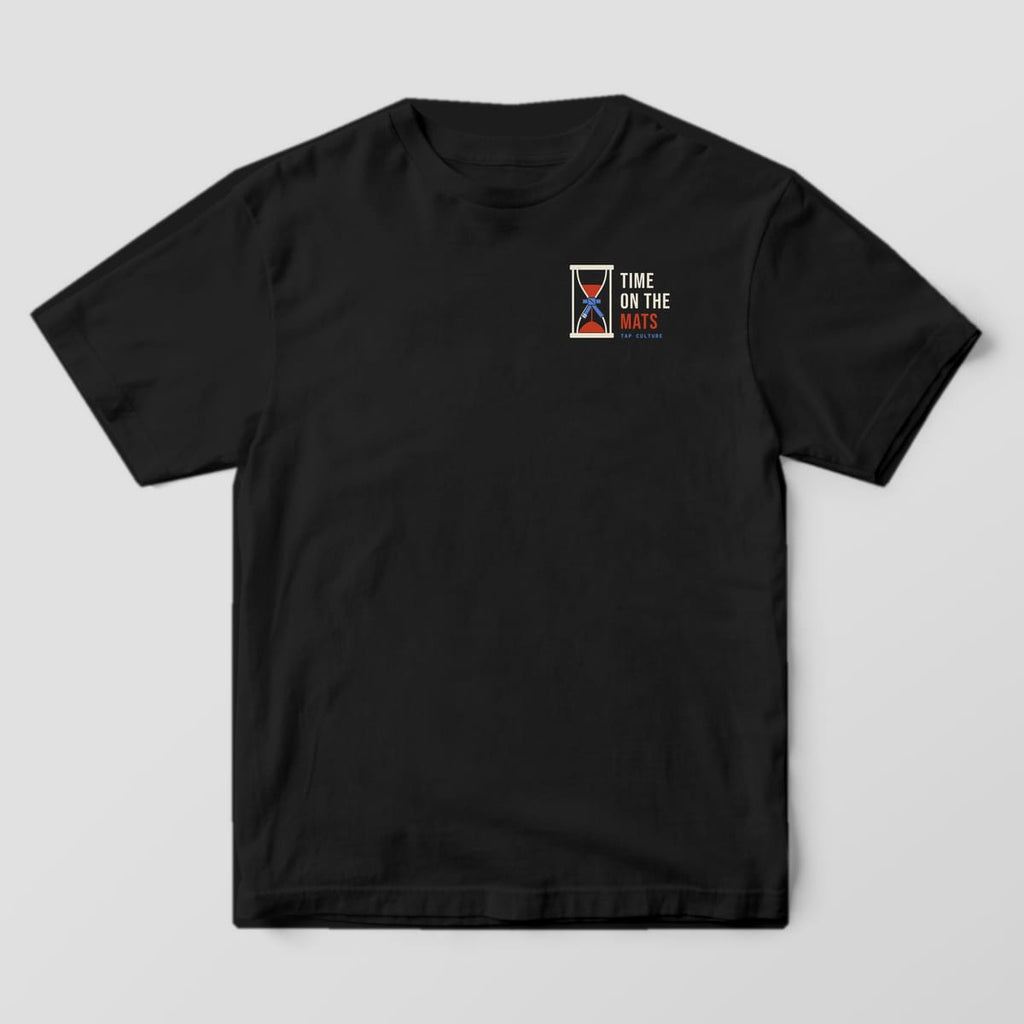 Front of a black Comfort Colors 1717 tee with a small hourglass tied with a blue belt and TIME ON THE MATS on the left chest.