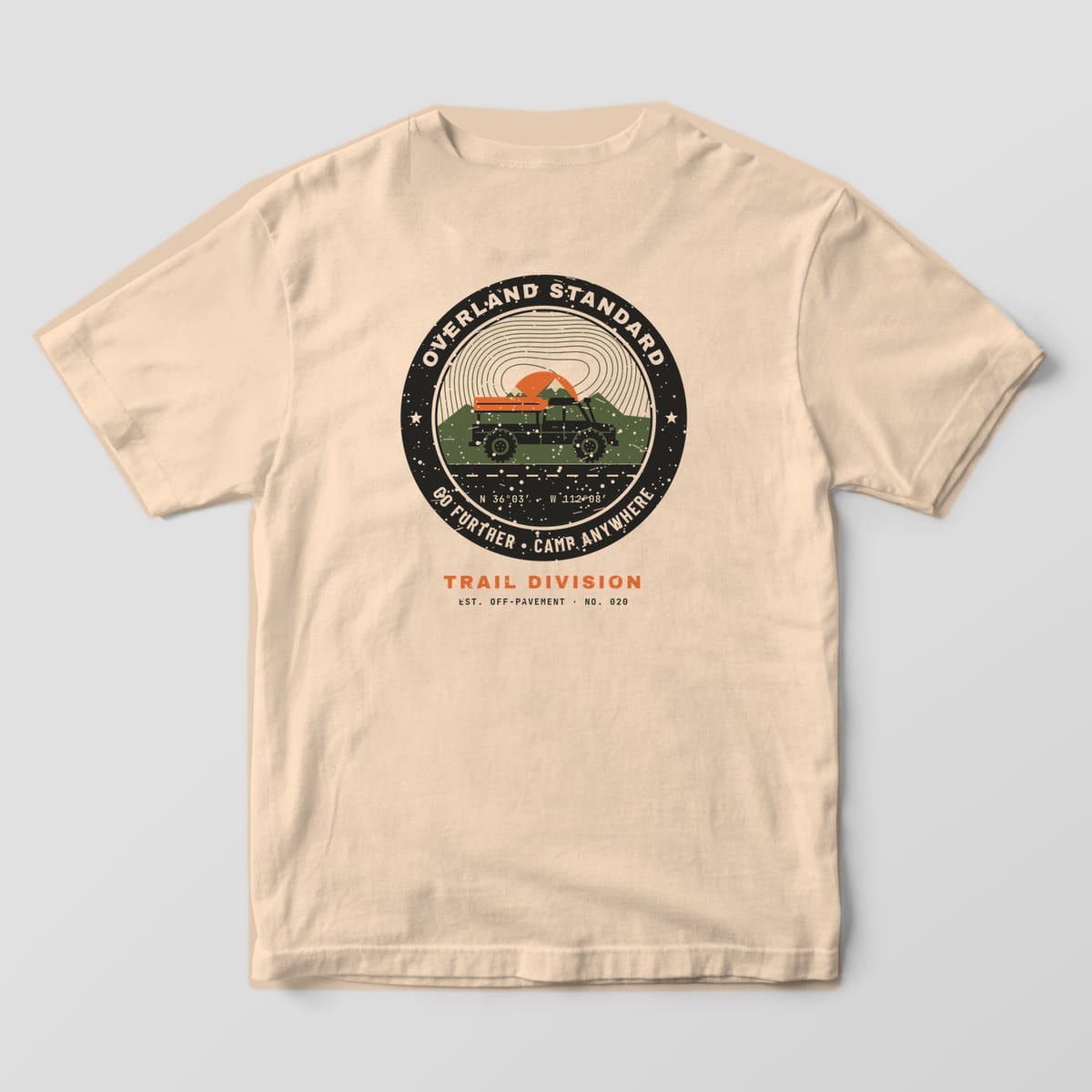 Back of a Ivory Comfort Colors 1717 tee with a black, orange and olive badge reading Overland Standard, Go Further, Camp Anywhere around a rooftop-tent truck.