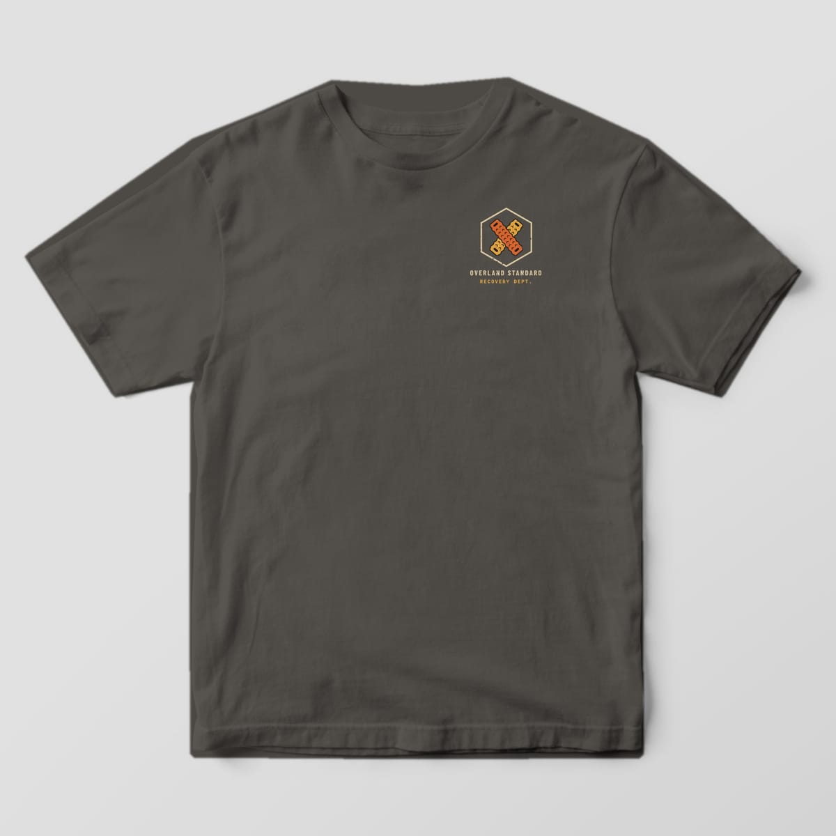 Front of a Pepper Comfort Colors 1717 tee with a small hexagon of crossed traction boards and the words Overland Standard Recovery Dept.