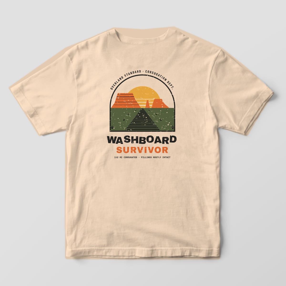 Back of a Ivory Comfort Colors 1717 tee with an arched scene of a rippled dirt road, orange mesas, striped gold sun and the words Washboard Survivor.