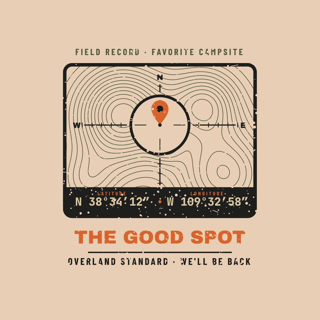 Close-up of the back print artwork on a ivory background: a topo map coordinate badge with a crosshair, orange map pin, latitude and longitude and the words The Good Spot