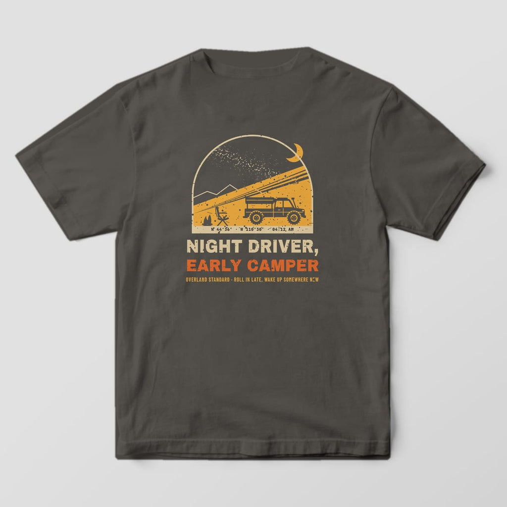 Back of a pepper Comfort Colors 1717 T-shirt showing an arched night camp scene with a headlamp beam lighting a rooftop tent truck under the Milky Way and the words Night Driver, Early Camper