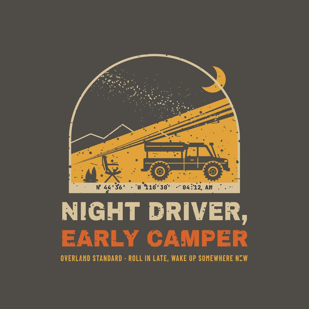 Close-up of the back print artwork on a pepper background: an arched night camp scene with a headlamp beam lighting a rooftop tent truck under the Milky Way and the words Night Driver, Early Camper