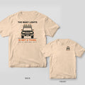 Back and front of a ivory Comfort Colors T-shirt with a front view of a boxy truck covered in auxiliary lights with rays and the words Too Many Lights Is Not a Thing; small chest print on the front