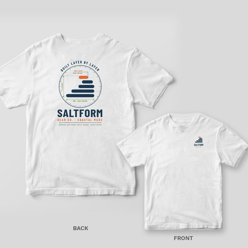 White Comfort Colors tee shown back and front: navy and orange layer-wave dial with BUILT LAYER BY LAYER and SALTFORM on the back, small logo on the chest.