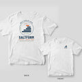 White Comfort Colors tee shown back and front: navy and orange layer-wave dial with BUILT LAYER BY LAYER and SALTFORM on the back, small logo on the chest.