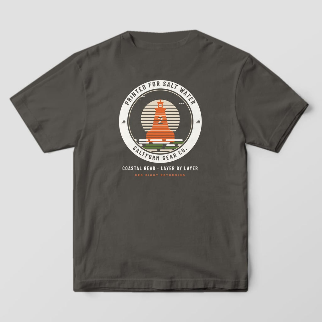 Back of a pepper gray Comfort Colors 1717 tee with an orange layered buoy inside a cream badge ring and COASTAL GEAR · LAYER BY LAYER.