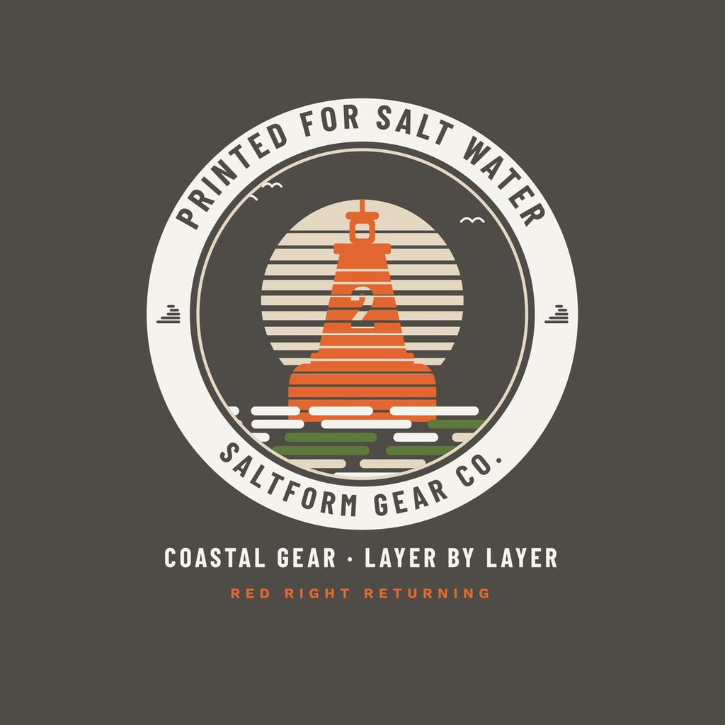 Close-up of the badge: orange number 2 buoy built from print layers, striped sand sun, marsh-green and cream water lines and ring lettering.