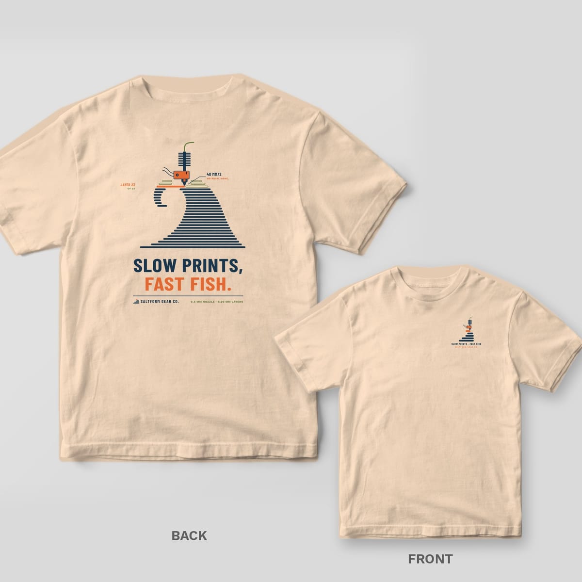 Ivory Comfort Colors tee back and front: navy layered wave being printed by an orange hotend with SLOW PRINTS, FAST FISH on the back, nozzle logo on the chest.