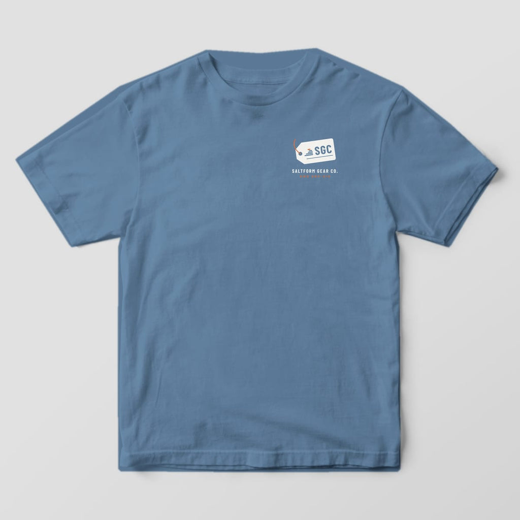 Front of a blue jean Comfort Colors 1717 tee with a small cream SGC gear tag and SALTFORM GEAR CO. on the left chest.