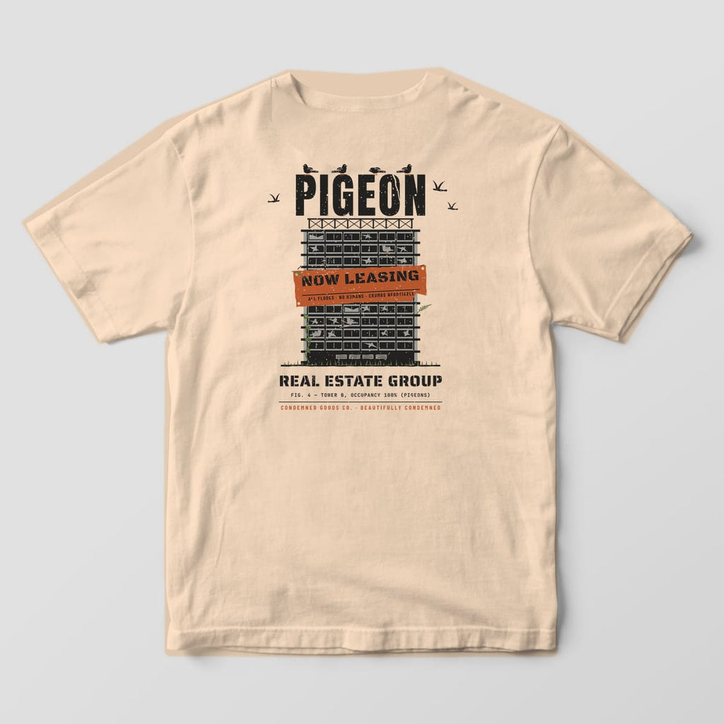 Back of an ivory Comfort Colors 1717 tee with a black and grey office tower print, pigeons, and a Now Leasing banner reading No Humans.