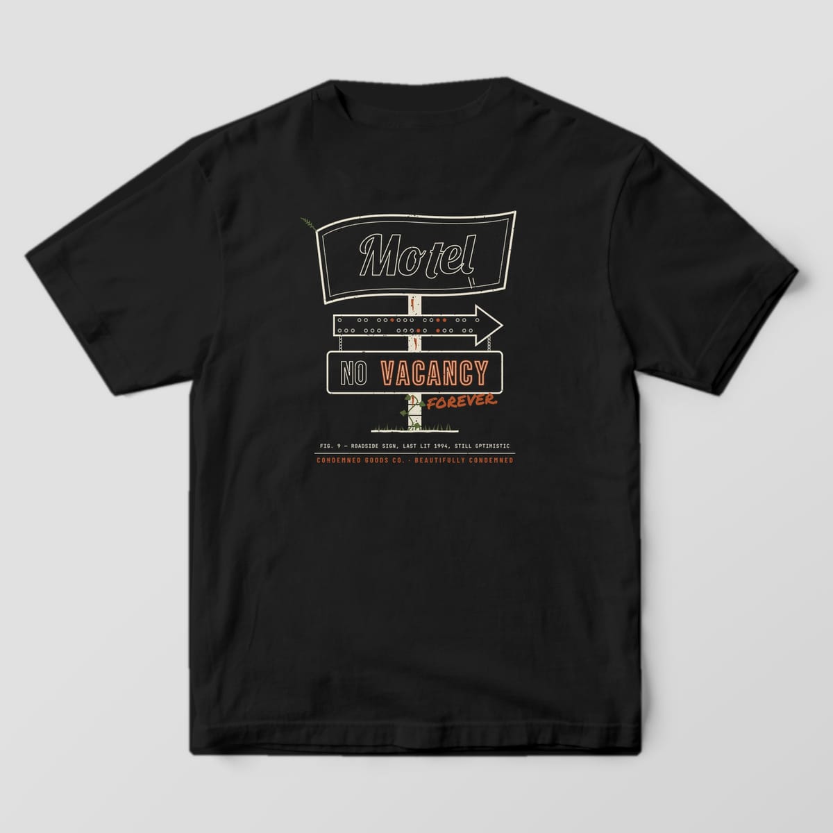 Back of a black Comfort Colors 1717 tee with a cream outline motel sign print and rust neon VACANCY lettering.