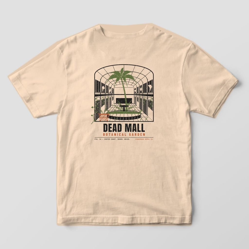 Back of a ivory Comfort Colors 1717 tee with an abandoned mall atrium with a palm tree growing out of the fountain under the words Dead Mall Botanical Garden.