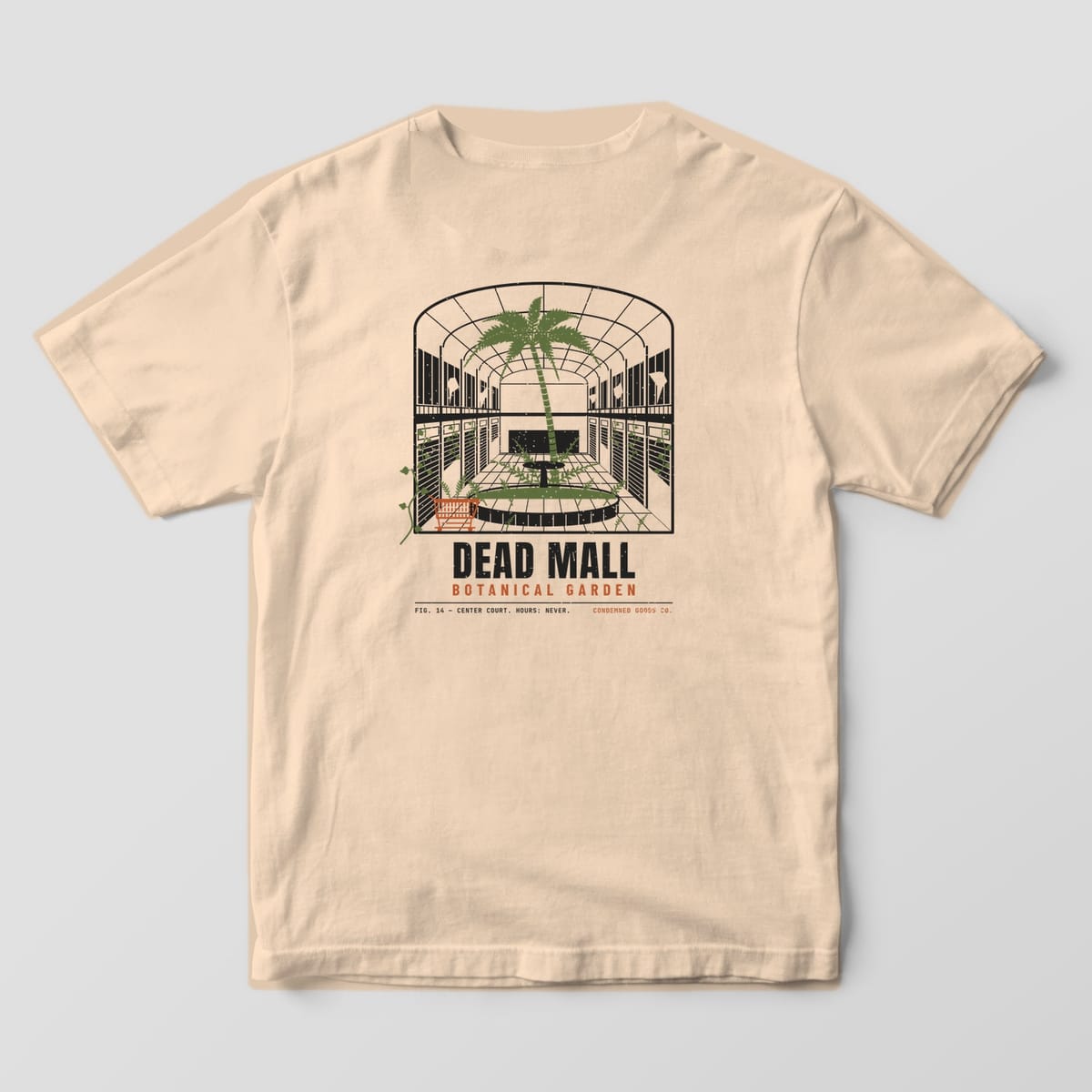 Back of a ivory Comfort Colors 1717 tee with an abandoned mall atrium with a palm tree growing out of the fountain under the words Dead Mall Botanical Garden.