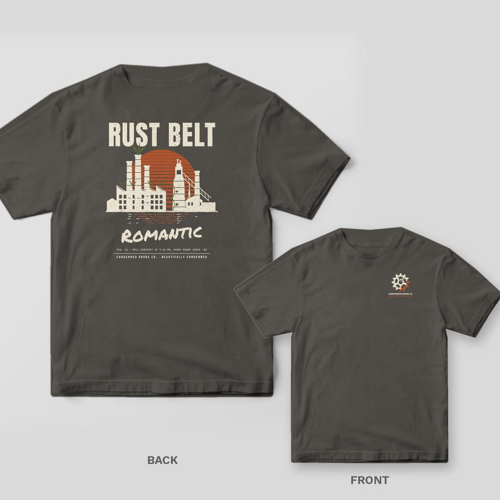 Pepper tee shown back and front: back has a cream factory skyline with smokestacks against a striped rust sunset under the words Rust Belt Romantic; front has a small rusted gear with ferns.
