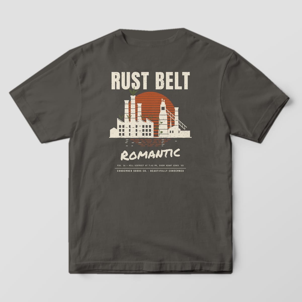 Back of a pepper Comfort Colors 1717 tee with a cream factory skyline with smokestacks against a striped rust sunset under the words Rust Belt Romantic.