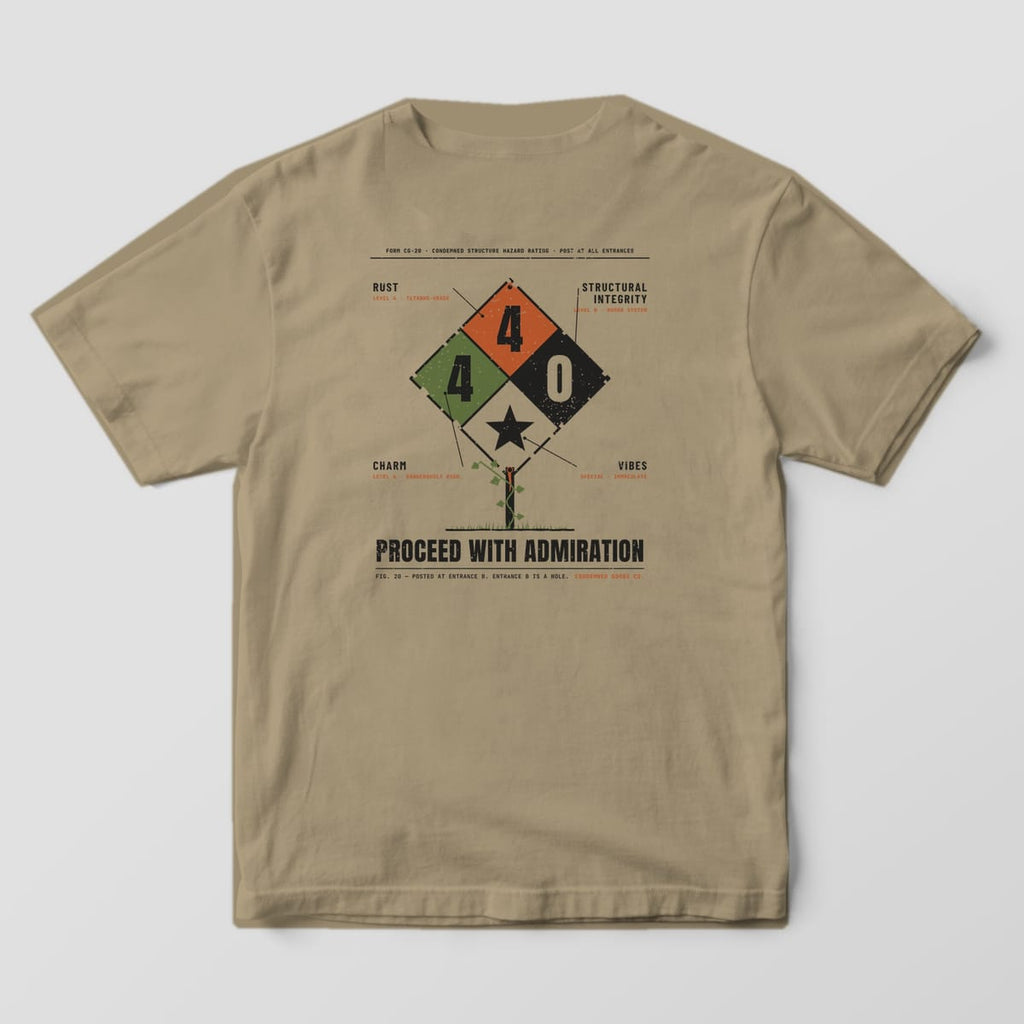 Back of a khaki Comfort Colors 1717 tee with a weathered hazard diamond rating Rust 4, Charm 4, Structural Integrity 0 above the words Proceed With Admiration.
