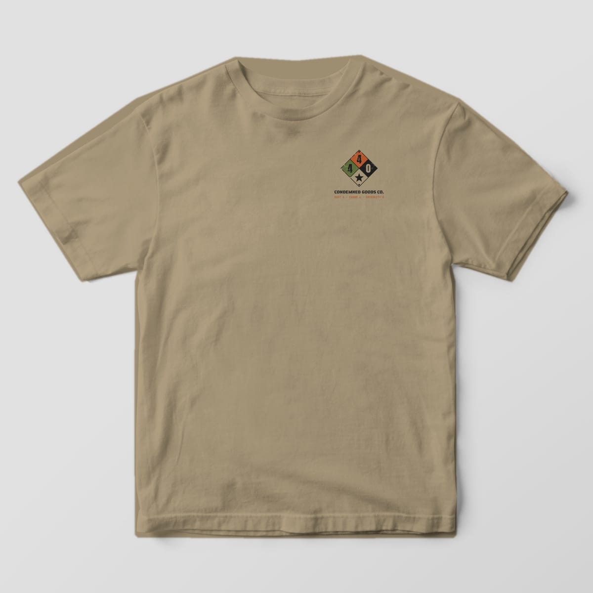 Front of a khaki Comfort Colors 1717 tee with a small four-color hazard diamond on the left chest.