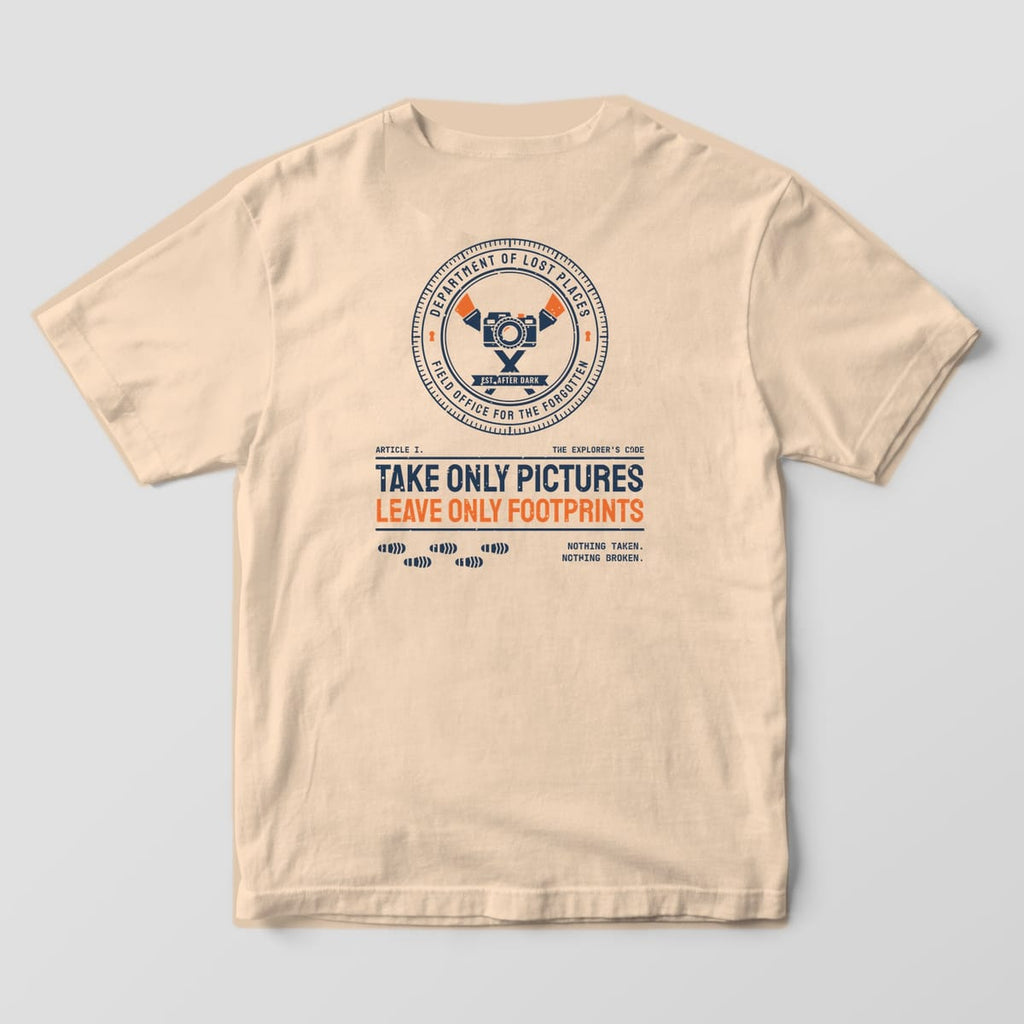 Back of an Ivory Comfort Colors 1717 tee printed with a navy and orange circular Dept. of Lost Places seal with a camera and crossed flashlights above the words Take Only Pictures, Leave Only Footprints and a trail of boot prints.