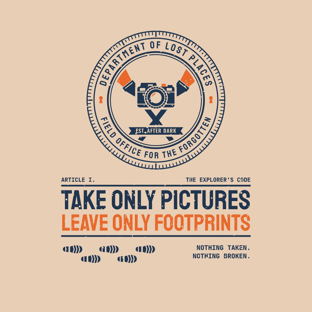 Back print artwork close-up: a navy and orange circular Dept. of Lost Places seal with a camera and crossed flashlights above the words Take Only Pictures, Leave Only Footprints and a trail of boot prints, lightly speckled.