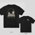 Black Comfort Colors tee shown back and front: the back has a cream and yellow night rooftop with water towers and a photographer at a tripod above Rooftop Survey Unit; the chest has a small water tower and moon.
