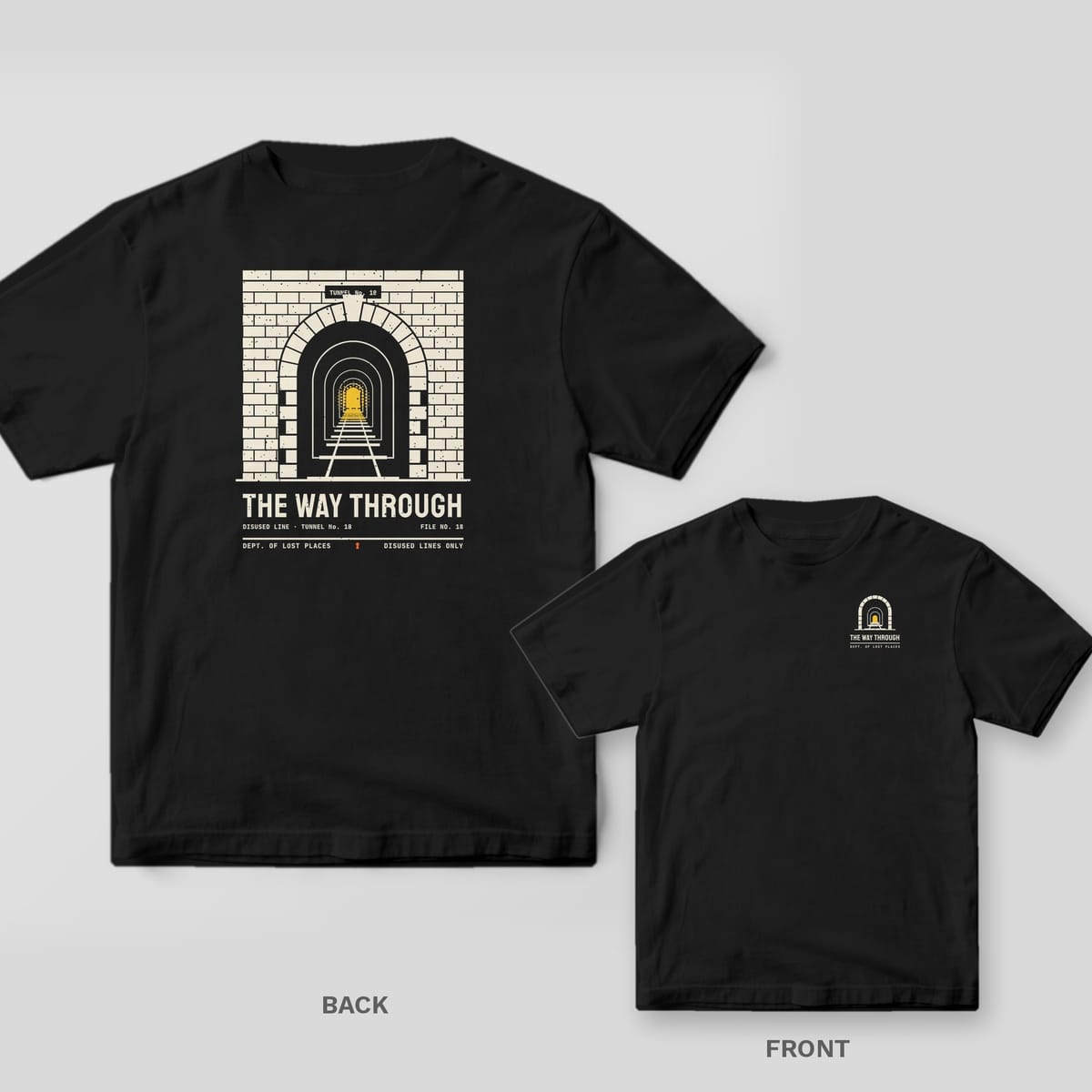 Black Comfort Colors tee shown back and front: the back has a cream brick railway tunnel with a yellow light at the end above The Way Through; the chest has a small tunnel.