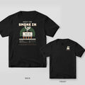 Black tee shown back and front: back has a cream chip letting out curling smoke over a green sunburst under the words Keep the Smoke In; front has a small smoking chip logo.