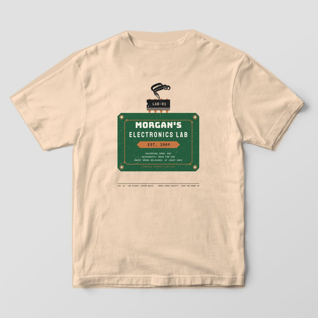 Back of an ivory Comfort Colors 1717 tee with a personalized green PCB plaque print, sample name MORGAN'S and EST. 2009.
