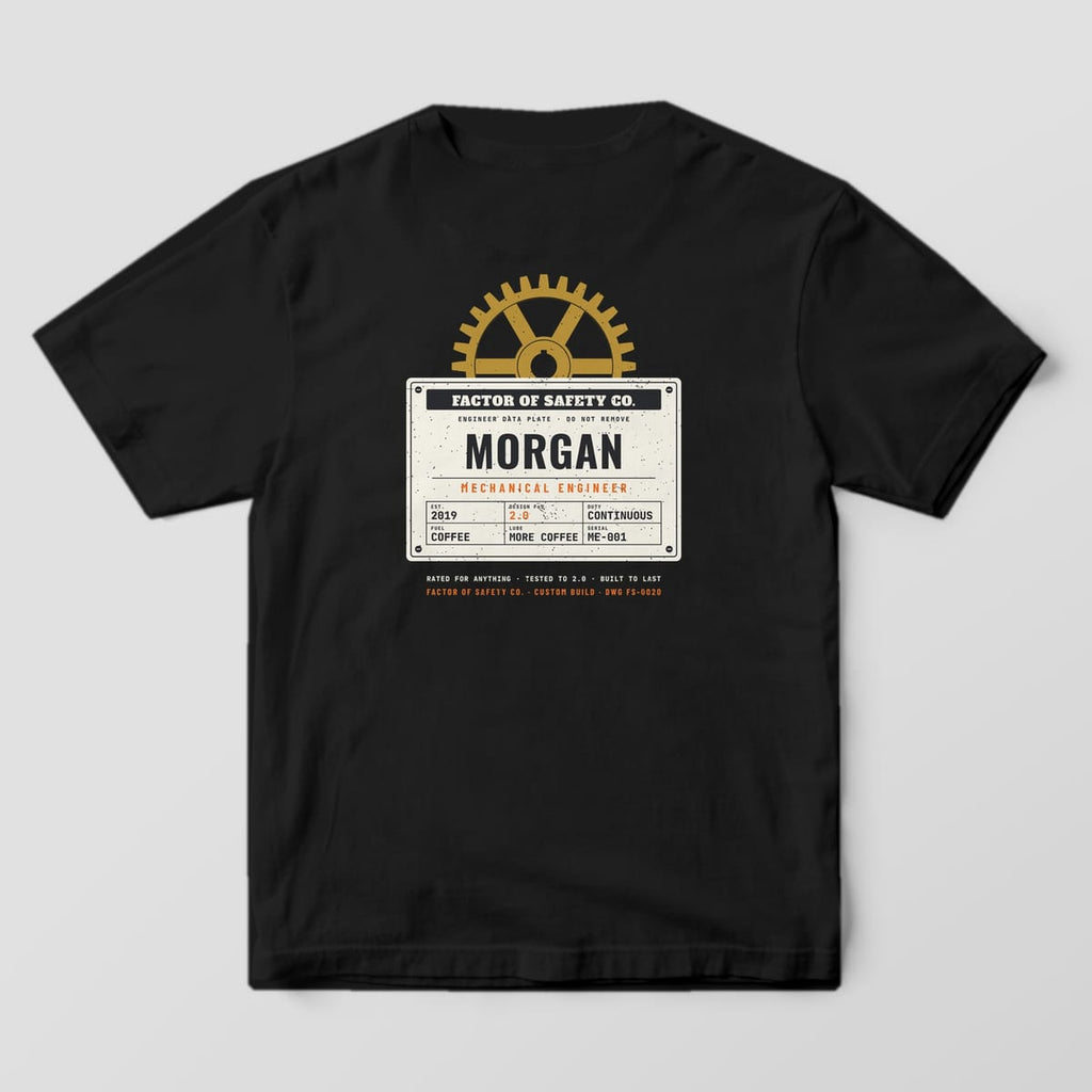 Back of a black Comfort Colors 1717 tee with the large Custom Mechanical Engineer print: a cream riveted data plate with a personalized name under a brass gear.