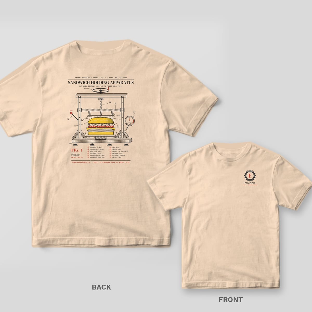 Ivory tee shown back and front: back has a vintage patent drawing of a sandwich held in an over-built steel clamp frame with numbered callouts; front has a small gear monogram reading Pat. Pend..