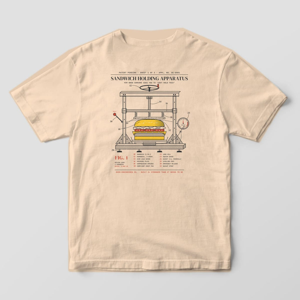Back of an ivory Comfort Colors 1717 tee with a vintage patent drawing of a sandwich held in an over-built steel clamp frame with numbered callouts.