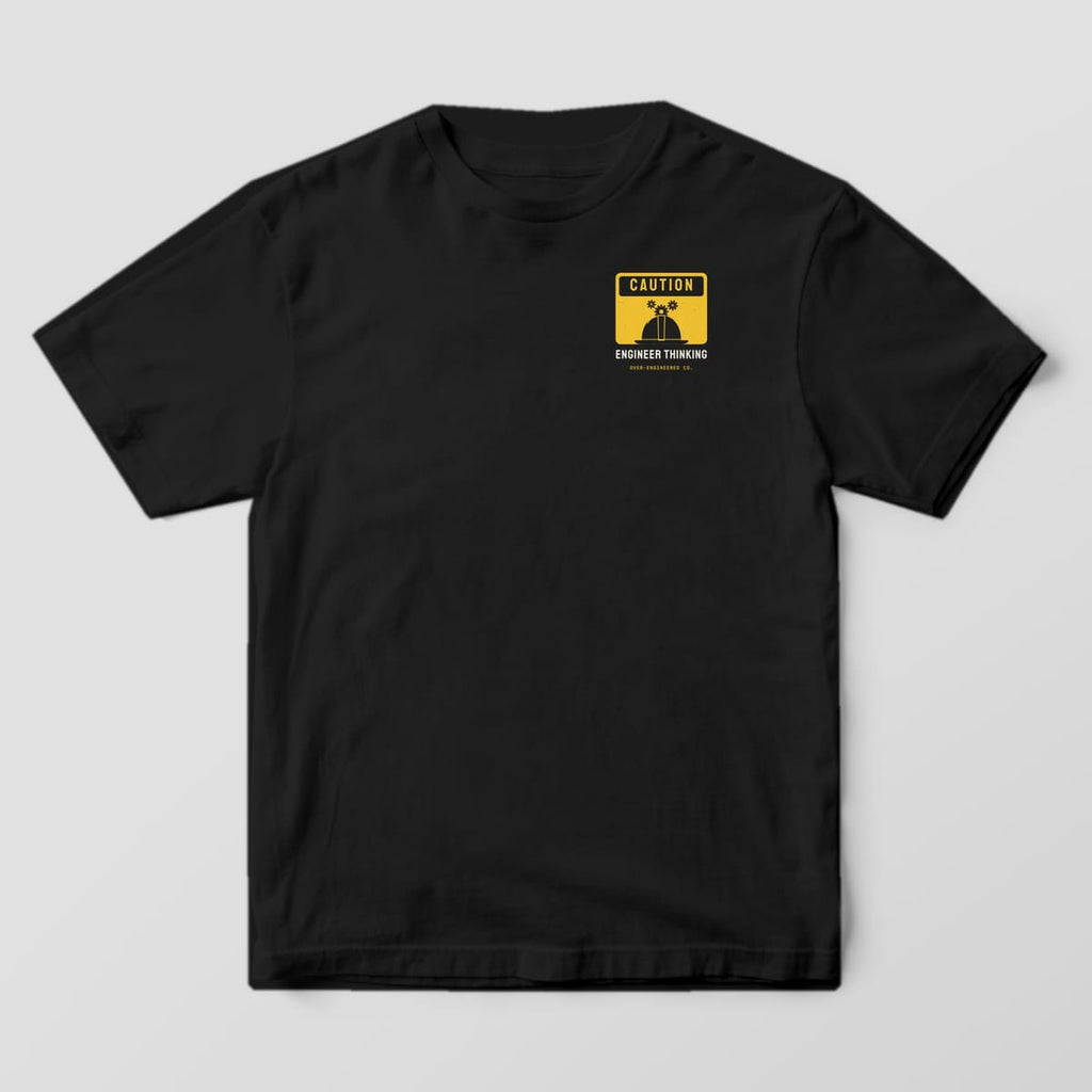 Front of a black Comfort Colors 1717 tee with a small yellow Caution sign with a hard hat on the left chest.