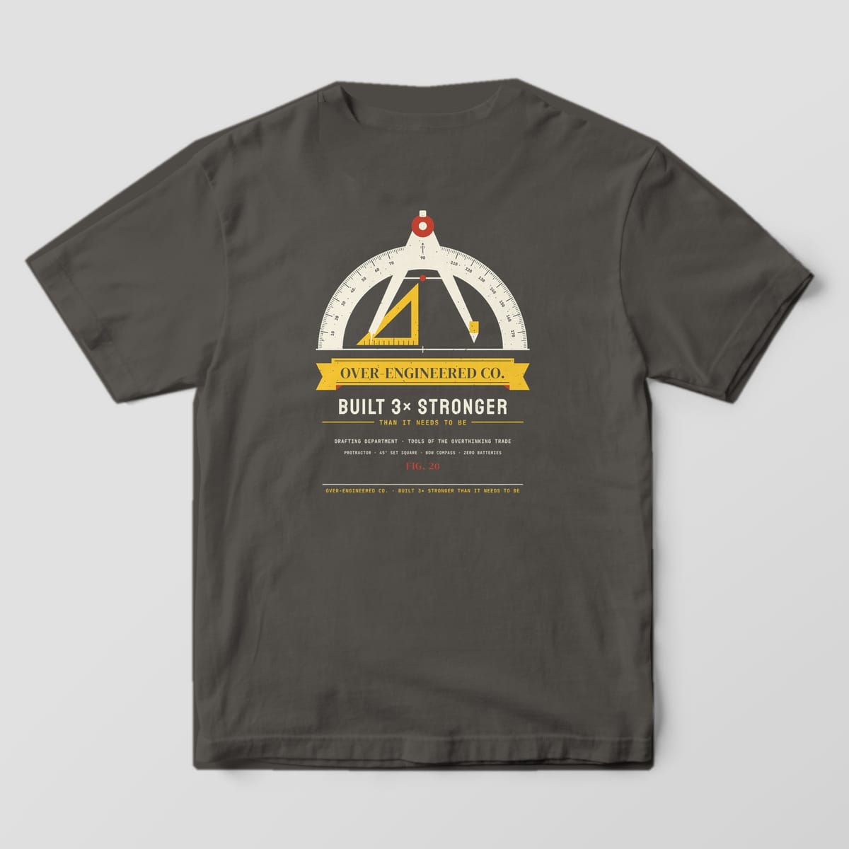 Back of a pepper Comfort Colors 1717 tee with a protractor, set square and compass crest with an Over-Engineered Co. ribbon.
