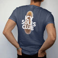 Man wearing a Navy tee, seen from the back: a translucent frosted sneaker outsole with frost crystals under Icy Soles in dripping ice letters and Club below, as a two-ink streetwear graphic in off-white and orange.