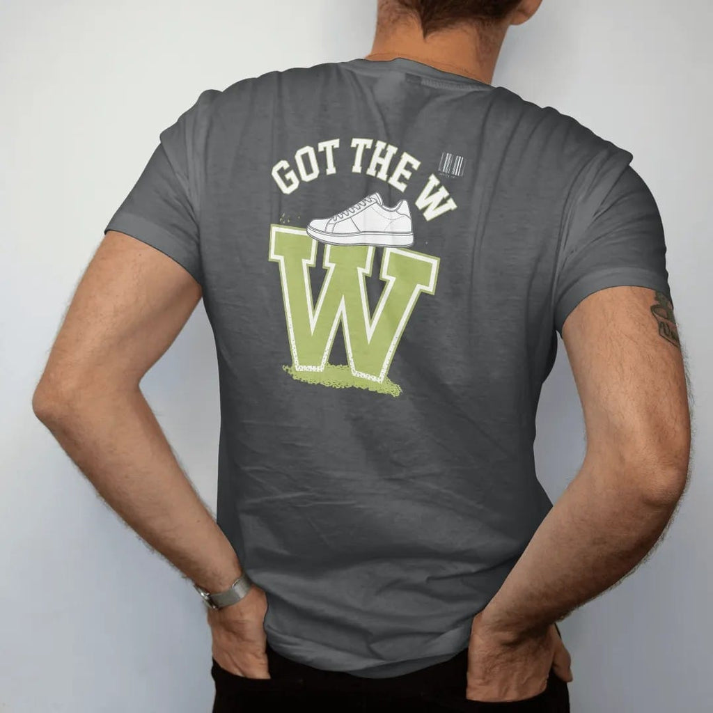 Man wearing a Graphite tee, seen from the back: a giant glowing W with a sneaker on top and bursting confetti under Got The W, as a two-ink streetwear graphic in off-white and lime.