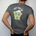 Man wearing a Graphite tee, seen from the back: a giant glowing W with a sneaker on top and bursting confetti under Got The W, as a two-ink streetwear graphic in off-white and lime.