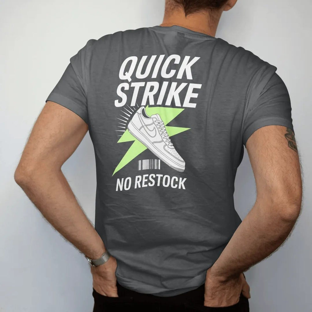Man wearing a Graphite tee, seen from the back: a sneaker bursting through a lightning bolt with speed lines under Quick Strike and stamped No Restock, as a two-ink streetwear graphic in off-white and lime.