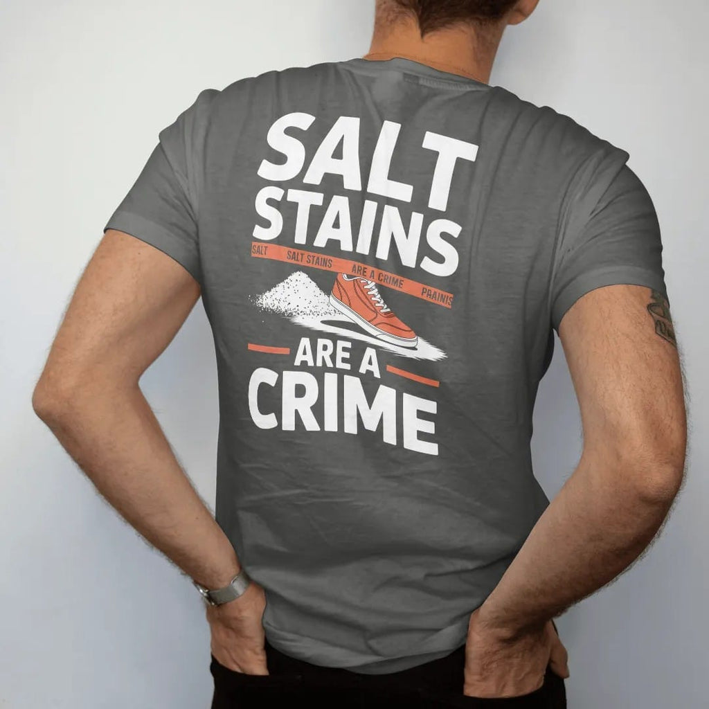 Man wearing a Pepper tee, seen from the back: a sneaker tiptoeing around road salt on a snowy sidewalk with police tape reading Salt Stains and Are A Crime below, as a two-ink streetwear graphic in off-white and orange.