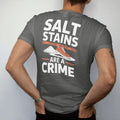 Man wearing a Pepper tee, seen from the back: a sneaker tiptoeing around road salt on a snowy sidewalk with police tape reading Salt Stains and Are A Crime below, as a two-ink streetwear graphic in off-white and orange.
